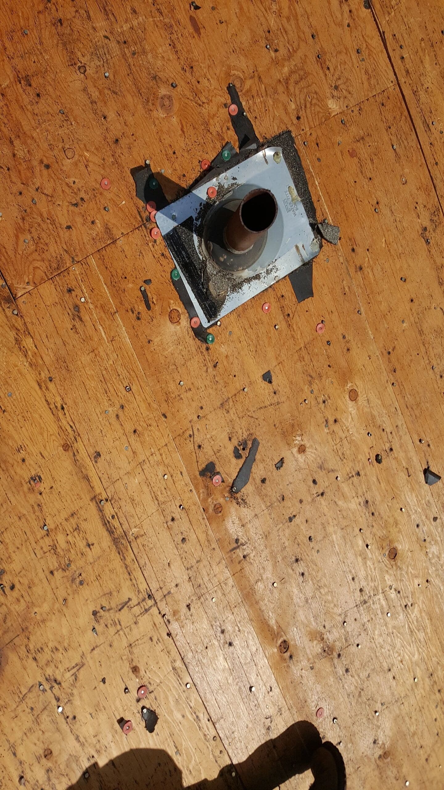 Tear-off stripped to the bare wood deck: plywood, nail plates and vent flashing on a real job