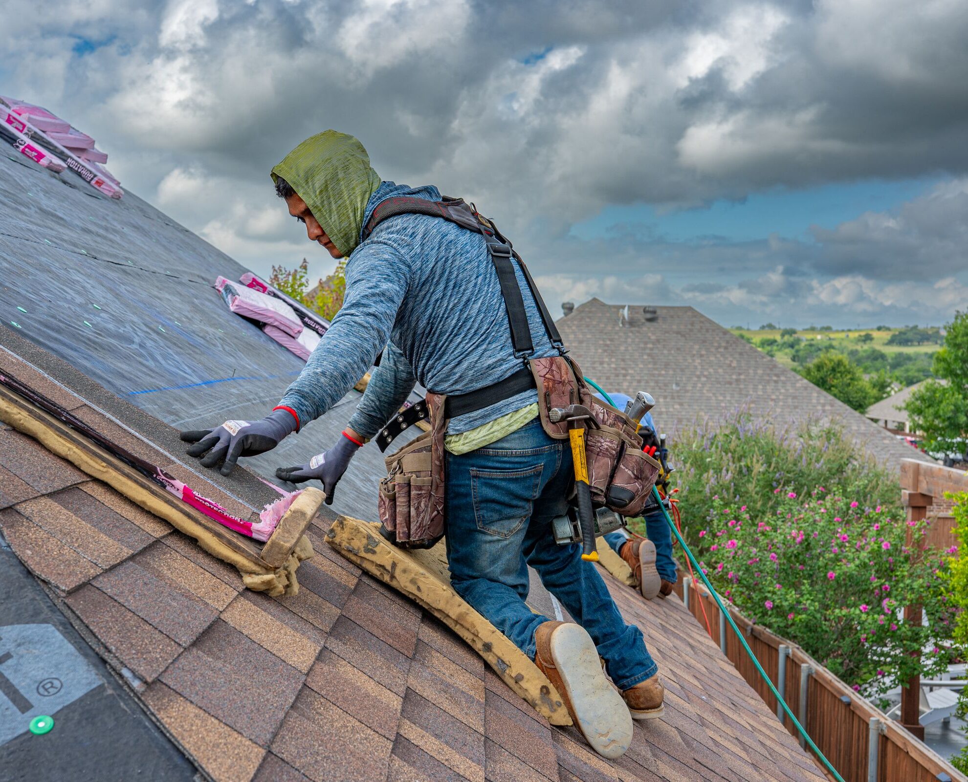 Roofer at work on a residential roof, illustrative