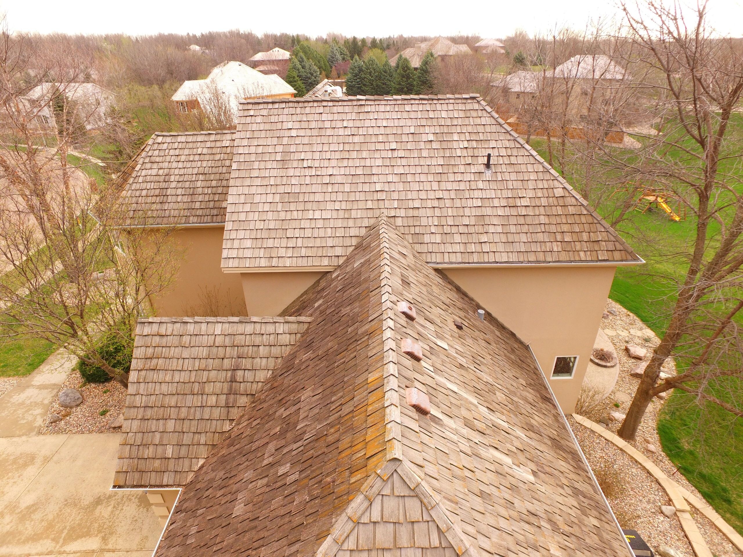 Aerial view of a cedar-shake roof on a Sioux Falls home, shot from Dakota Roofing's drone